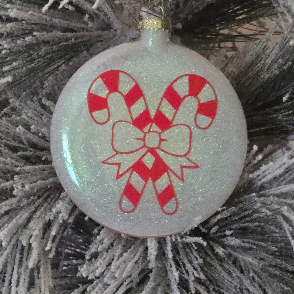 Decorative Christmas ornament with candy cane design on a frosted branch.