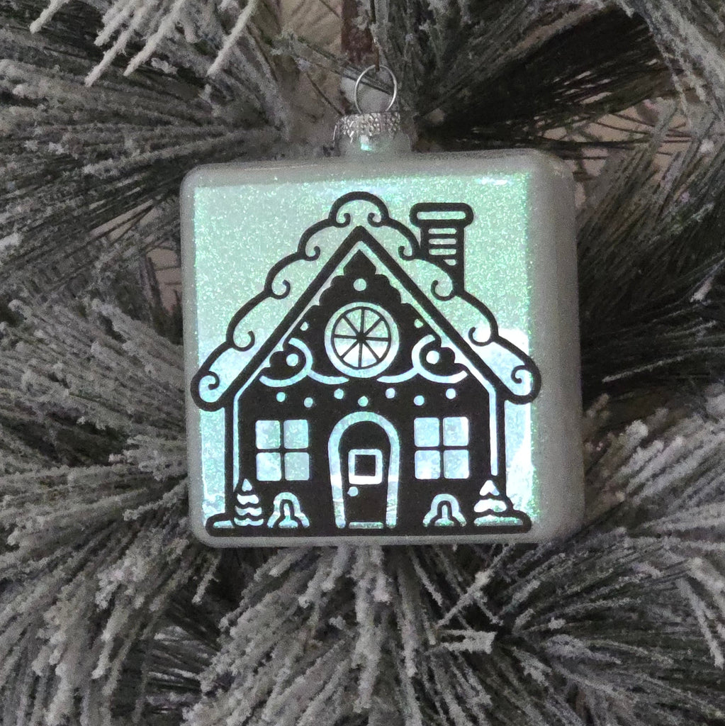 Decorative Christmas ornament  with  gingerbread house design on a tree branch