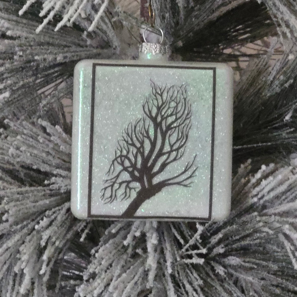 Square ornament with tree design on a frosted branch