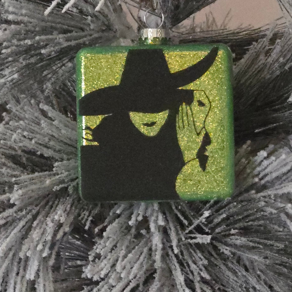Decorative ornament with a silhouette  witch design on a green background, 